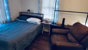 een slaapkamer met een bed en een bank bij Quiet Private Room at McAfee Shared Bathroom Room 3 in Decatur