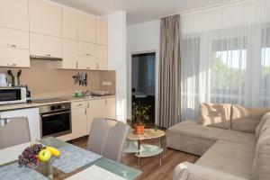 a kitchen and living room with a couch and a table at Boró Apartman in Tiszafüred