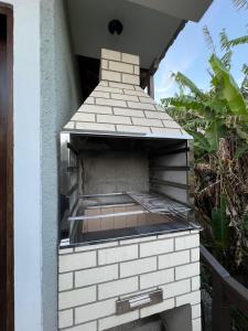 een pizza-oven buiten aan de zijkant van een gebouw bij Casa Brisa do Siriú in Garopaba