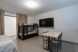 una camera da letto con un letto, un tavolo e una televisione di Kitnet 03 Pet friendly com Wi-Fi e Garagem a Bragança Paulista