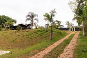 una strada sterrata con palme su una collina di Kitnet 03 Pet friendly com Wi-Fi e Garagem a Bragança Paulista
