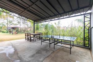 un tavolo in vetro e panche su un patio di Kitnet 03 Pet friendly com Wi-Fi e Garagem a Bragança Paulista