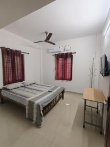 ein Schlafzimmer mit Bett und Deckenventilator in der Unterkunft Beevis Gray, Kazhakuttoom in Kaniyapuram