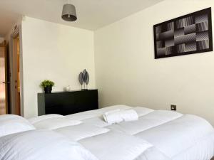 a white bed in a room with a tv on the wall at York City Centre 2 bed Flat with Disable Access 2 bath - Balcony and City View in York