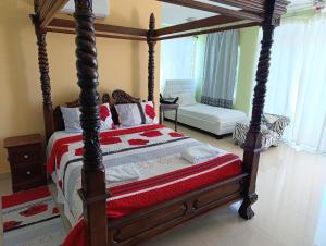 une chambre avec un grand lit en bois à baldaquin dans l'établissement Hotel Don Michele, à Boca Chica