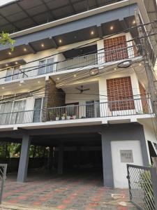 Großes weißes Gebäude mit Balkon in der Unterkunft Beevis Gray, Kazhakuttoom in Kaniyapuram