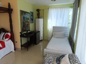 une chambre avec deux lits, un bureau et une fenêtre dans l'établissement Hotel Don Michele, à Boca Chica