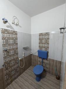 ein Badezimmer mit einem blauen WC und einer Dusche in der Unterkunft Beevis Gray, Kazhakuttoom in Kaniyapuram