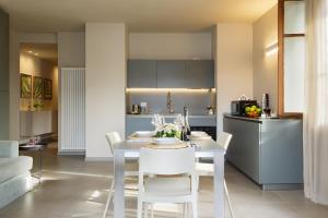 een keuken en eetkamer met een witte tafel en stoelen bij Orta Paradise 26 in Orta San Giulio +9 foto's
