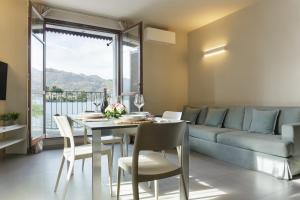 een eetkamer met een tafel, stoelen en een bank bij Orta Paradise 26 in Orta San Giulio