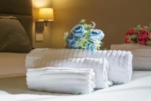 een bed met twee witte handdoeken en bloemen erop bij Orta Paradise 26 in Orta San Giulio