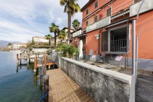 een gebouw met een dok naast een waterlichaam bij Orta Paradise 26 in Orta San Giulio