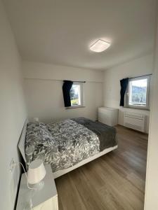 Un dormitorio con una cama y dos ventanas. en Appartamenti Cataleya, en Cuccurano