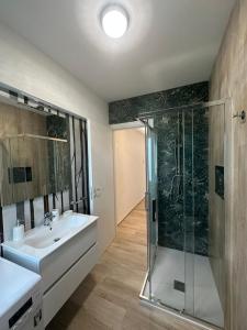 Un baño con ducha de cristal y lavabo. en Appartamenti Cataleya, en Cuccurano