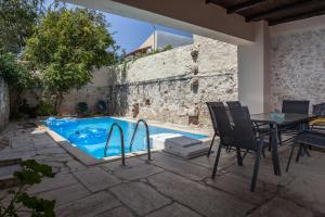 a patio with a table and chairs next to a swimming pool at Casa del Maestro in Prinés