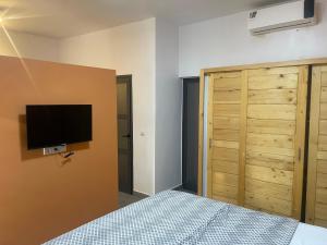 a bedroom with a bed and a tv on the wall at Chez Elisa in Mbour