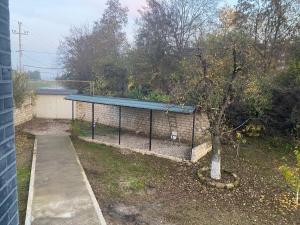 a building with a fence next to a tree at Дом в Гусаре in Qusar