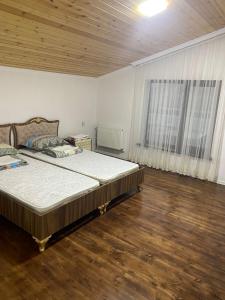 a bedroom with a large bed and a wooden floor at Дом в Гусаре in Qusar
