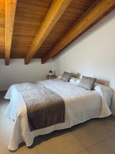 um quarto com uma cama grande e tectos em madeira em El Sueño De Albarracín II Duplex em Albarracín