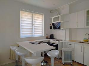 een keuken met een witte tafel en witte stoelen bij CityPark BnB in Pristina +7 foto's