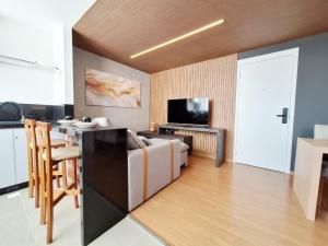 a kitchen and living room with a couch and a television at LK Barro Preto 16 in Belo Horizonte