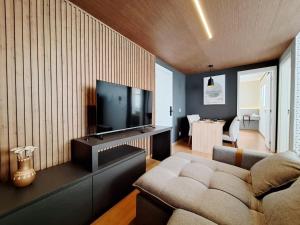 a living room with a couch and a flat screen tv at LK Barro Preto 16 in Belo Horizonte