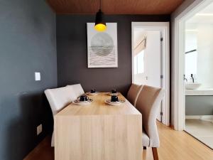a dining room with a wooden table and two chairs at LK Barro Preto 16 in Belo Horizonte