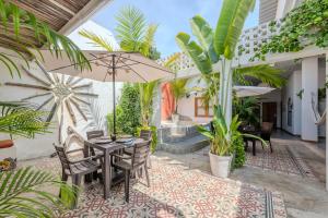 a patio with a table and chairs and plants at Casa Moraira in Cartagena de Indias