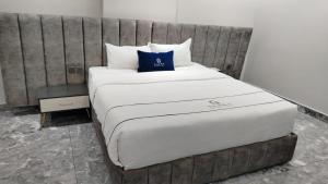 een groot bed met een blauw kussen erop bij فندق جولدن نيو جوان HOTEL GOLDEN NEW jWan in Abha