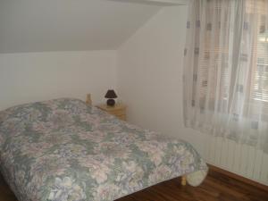 a bedroom with a bed with a floral bedspread at Kisiovi Apartment in Devin