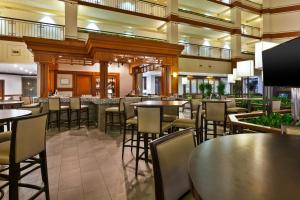 a restaurant with tables and chairs and a bar at Hotel Auburn Hills in Auburn Hills