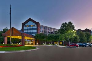 a building with a car parked in a parking lot at Hotel Auburn Hills in Auburn Hills