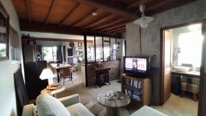 un salon avec une télévision et une table dans l'établissement Le Clos de Marenla, à Marenla