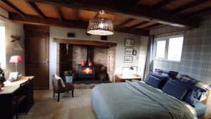 - une chambre avec un lit et une cheminée dans l'établissement Le Clos de Marenla, à Marenla