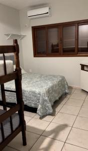 een slaapkamer met een bed en een stoel erin bij Casa Brisa do Siriú in Garopaba