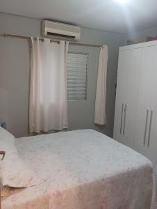 una camera con un letto e una finestra con condizionatore d'aria di Casa ap a Bertioga