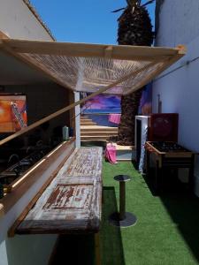 een houten bank in een kamer met een tafel bij Aotea Backpacker Hostel in Iquique