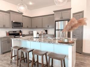 eine Küche mit einer Theke mit Hockern drum herum in der Unterkunft Beautiful 3BD 2B - Weatherford - Same Day Bookings in Weatherford