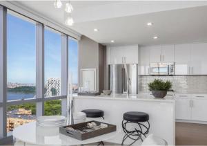 eine Küche mit weißen Schränken und einem großen Fenster in der Unterkunft Everlasting Reality in Fort Lee