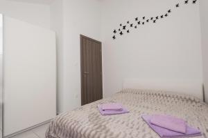 a bedroom with a bed with purple towels on it at Apartments Atlas Grubišić in Primošten +27 photos