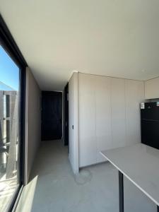 een keuken met witte kasten en een groot raam bij Rompe Olas in Maitencillo +1 foto