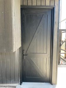 een houten deur in een gebouw met asfalt bij Rompe Olas in Maitencillo