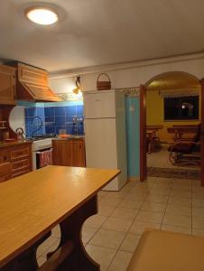 eine Küche mit einem Kühlschrank und einem Tisch darin in der Unterkunft Hacjenda - Apartamenty i Pokoje Gościnne in Czarna Góra