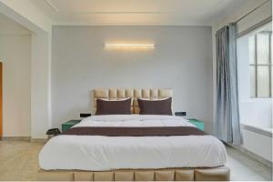 een slaapkamer met een groot bed en een raam bij Collection O by OYO HOTEL DLF PHASE-4 MG ROAD in Gurgaon