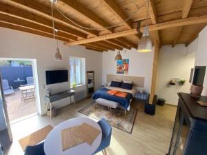 a bedroom with a bed and a living room at A la Belle Etoile in Montbrison