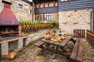 una mesa de picnic en un patio trasero con chimenea en La Congosta, mágica aldea rodeada de montañas, en La Plaza