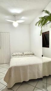 ein Schlafzimmer mit Bett und Deckenventilator in der Unterkunft Casa a 100mts da praia in Ilhabela + 14 Fotos