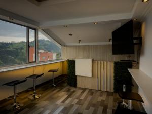 a room with stools in a room with a large window at Hotel Bussines Center in Quito