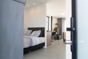 een slaapkamer met een bed en een bureau erin bij Villa View in Alkmaar