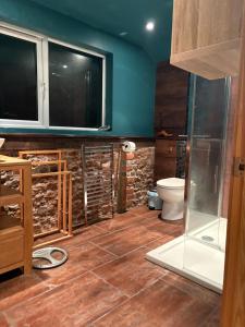 Un baño con inodoro y un televisor en la pared. en High Barn, en Thursley